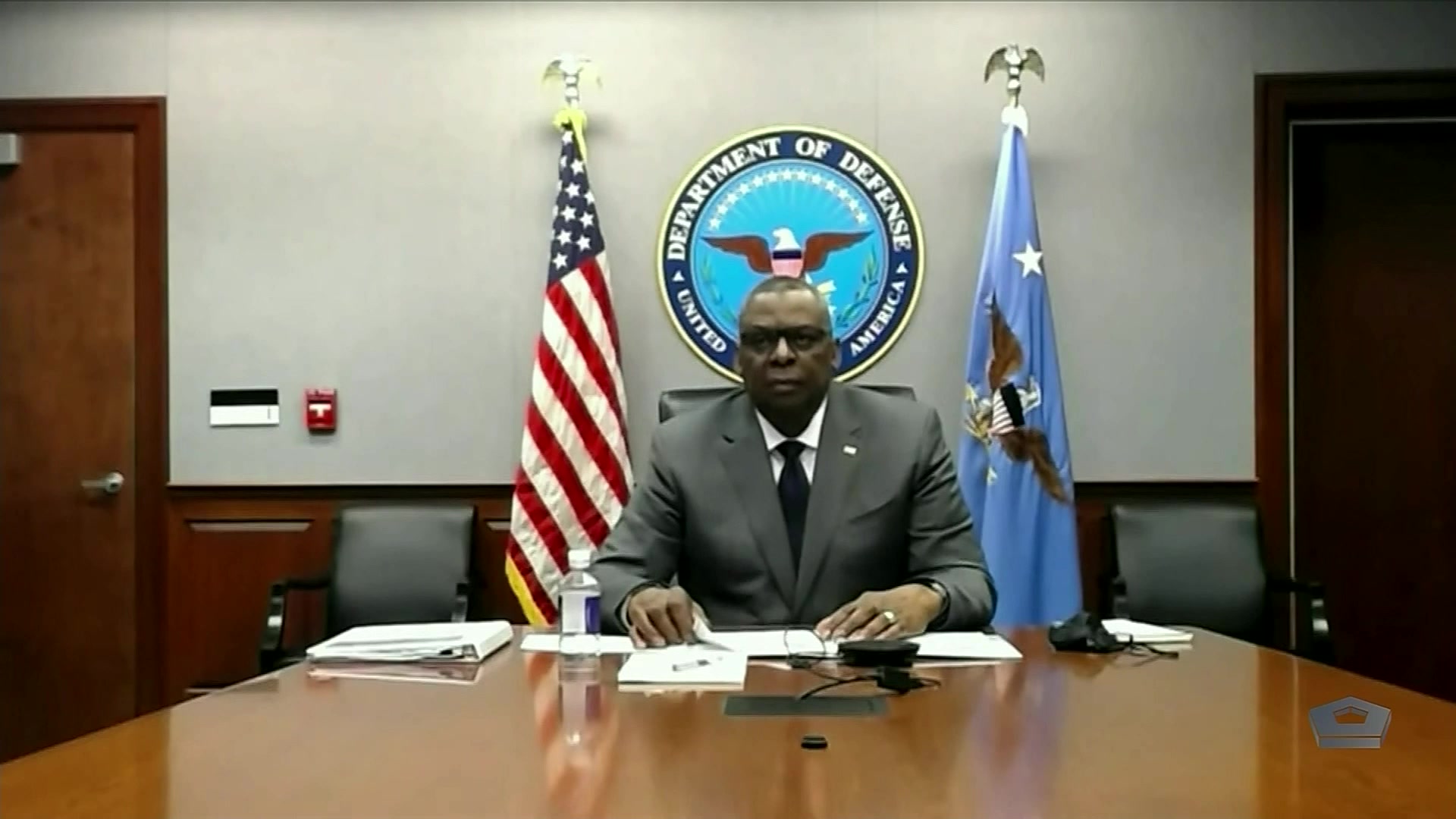 Secretary of Defense Lloyd J. Austin III sits at a desk.