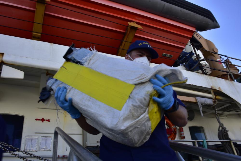 A crew member of the Coast Guard Cutter Dauntless offloads a bale of illegal narcotics at Base Miami Beach, Florida, Dec. 7, 2021. The contraband was seized by members of the Royal Fleet Auxiliary Wave Knight and the His Netherlands Majesty’s Ship Holland during three separate interdictions in the Caribbean Sea. (U.S. Coast Guard photo by Petty Officer 3rd Class Brian Zimmerman)