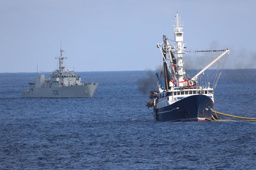 Royal Canadian Navy members of Her Majesty's Canadian Ship Yellowknife work alongside members of the United States Coast Guard Law Enforcement Detachment