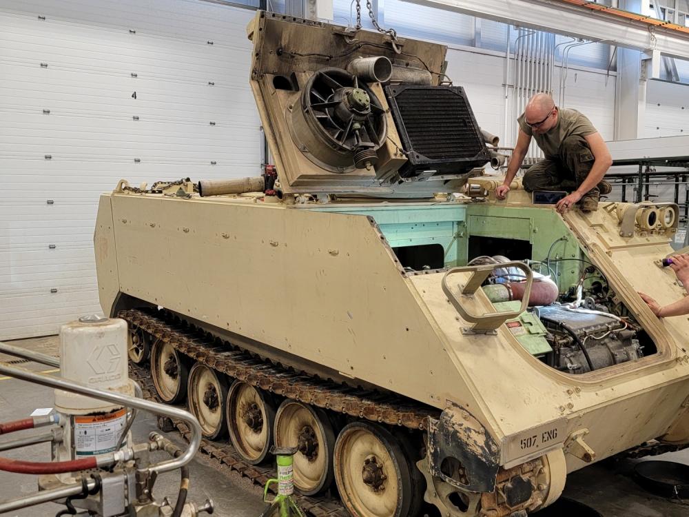 A mechanic provides maintenance on an M113A3 Armored Personnel Carrier