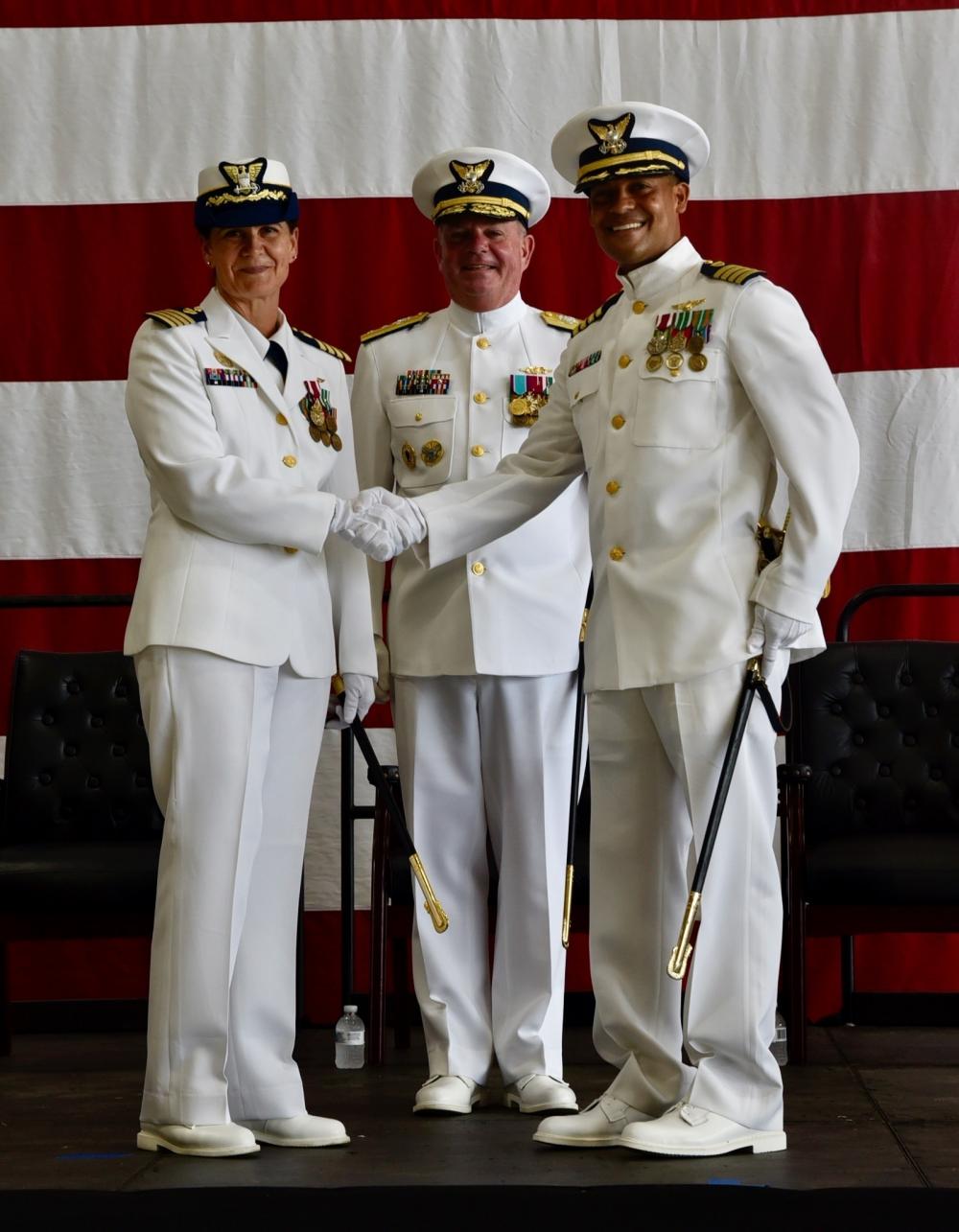 Capt. Lawrence Gaillard (right) shakes hands with Capt. Tina Peña (left), and Rear Adm. Brendan C. McPherson (center), during Air Station Borinquen's Change of Command in Aguadilla, Puerto Rico June 17, 2022. During the ceremony, Capt. Gaillard relieved Capt. Peña as the new commanding officer of Air Station Borinquen. (U.S. Coast Guard photo by Ricardo Castrodad)