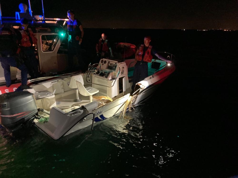 Coast Guard Station Miami Beach small boat crew inspecting a boat that was part of a collision near Key Biscayne, Florida, June 17, 2022. Coast Guard, Miami-Dade Fire Rescue, Miami-Dade Police Department, and Florida Fish and Wildlife crews assisted 10 people and recovered two bodies after their vessels collided. (U.S. Coast Guard photo by Station Miami Beach)