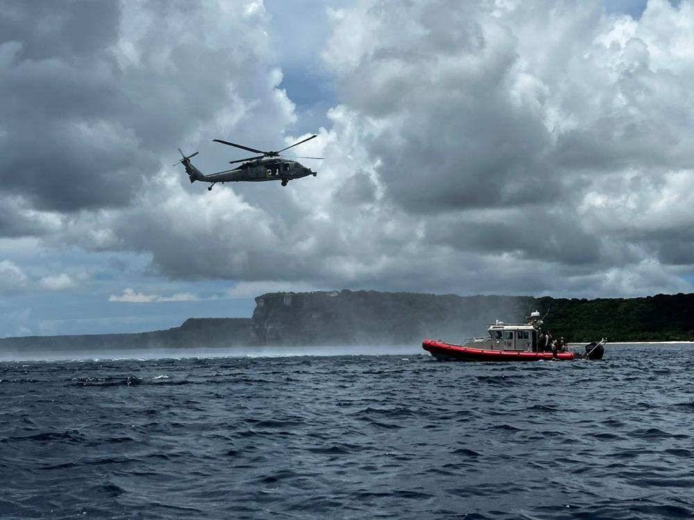 A U.S. Navy Helicopter Sea Combat Squadron Two-Five MH-60S Knighthawk helicopter crew approaches a Guam Fire Rescue boat during an exercise in Tumon Bay Aug. 11, 2022.