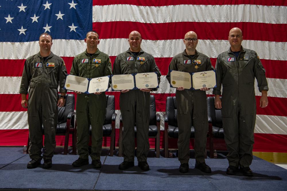 Cmdr. Ryan Matson, left, commanding officer of Coast Guard Air Station Houston, Cmdr. James Conner, middle left, an MH-65 Dolphin helicopter pilot, Petty Officer 1st Class Vincent Neiman, middle, an aviation survival technician, Petty Officer 2nd Class Christopher Collins, middle right, an aviation maintenance technician, and Rear Adm. Richard V. Timme, right, commander, Coast Guard District Eight, pose for a photo during an award ceremony Coast Guard Air Station Houston, Texas, Aug. 19, 2022. During the ceremony, Timme presented Air Medals to Conner, Neiman, and Collins for rescuing nine trapped crew members from the Pride Wisconsin, a decommissioned mobile offshore drilling unit that caught fire in Sabine Pass, Texas, on Feb. 24, 2022. (U.S. Coast Guard photo by Petty Officer 2nd Class Ryan Dickinson)