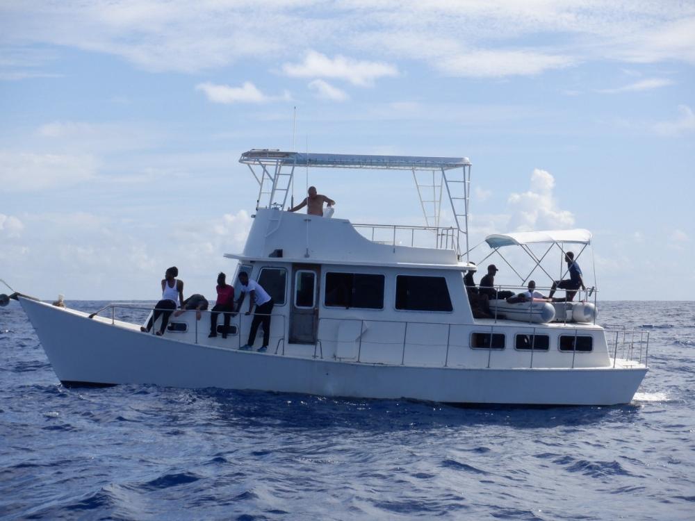 This is the overloaded 40-foot cabin cruiser Power Whirl with men, women and children aboard waving their arms through the windows about 20 miles off Boca Raton, Florida, Oct. 12, 2022. The people were transferred to Bahamian authorities on. Oct. 16, 2022. (U.S. Coast Guard photo by Coast Guard Cutter Dependable's crew)