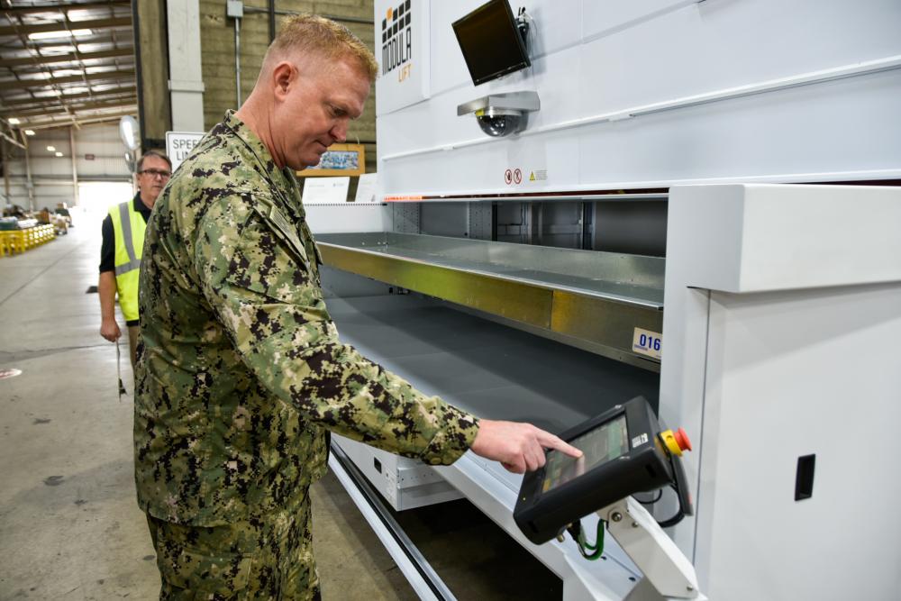 Capt. Cory Schemm, commanding officer NAVSUP FLC San Diego, tests one of the Modula Vertical Lift Modules at the 5G smart warehouse located on Naval Air Station North Island Oct. 28.