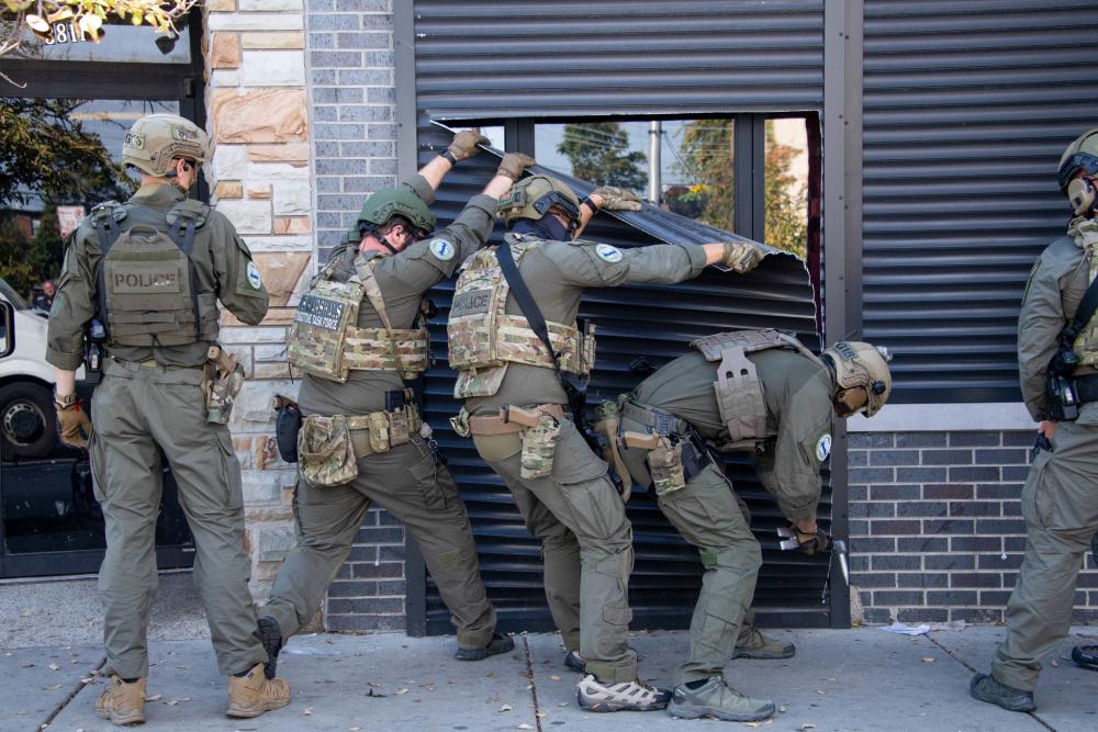 A Special Response Team (SRT) from Homeland Security Investigations (HSI) peels open a security door while serving a warrant as part of Operation Boiling Point