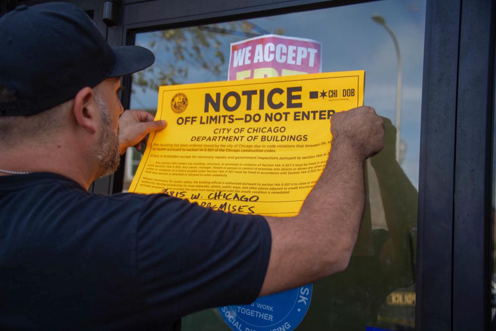 A special agent from Homeland Security Investigations (HSI) places an off limits sign on the location that was investigated by HSI as part of a stolen pharmaceutical ring during Operation Boiling Point