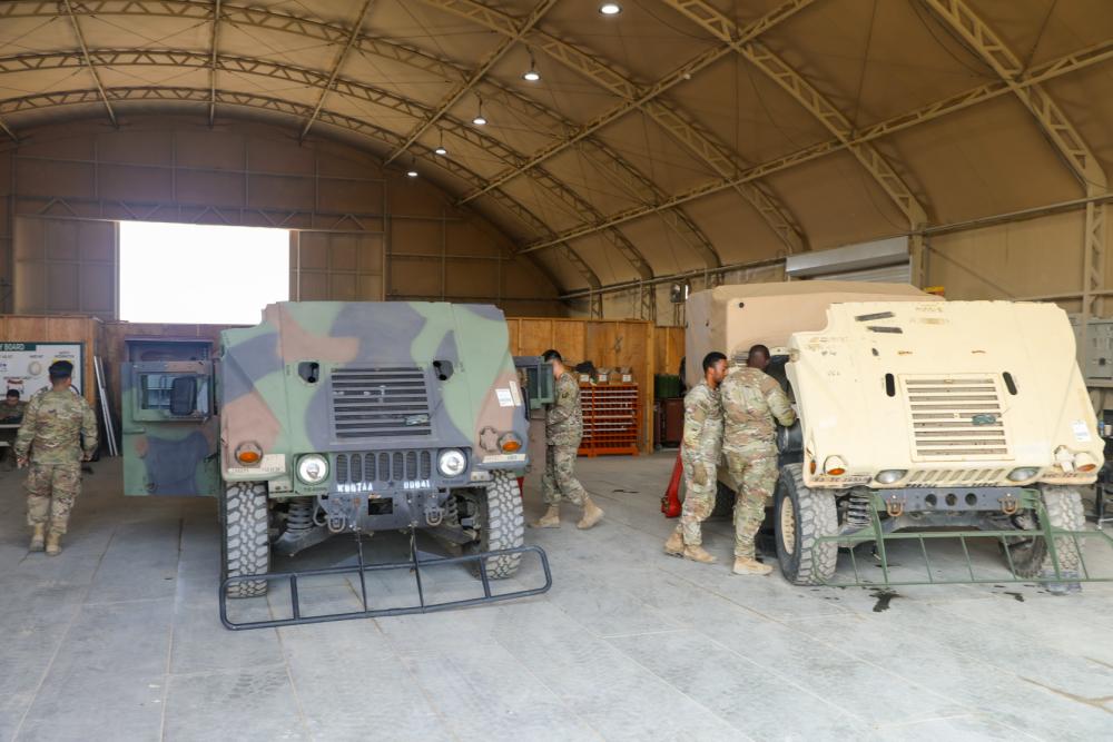 Soldiers with the 369th Sustainment Brigade work on HMMWVs in the unit’s motor pool
