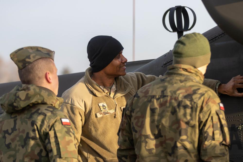 U.S. Army Soldier shows Polish military the AH-64 Apache