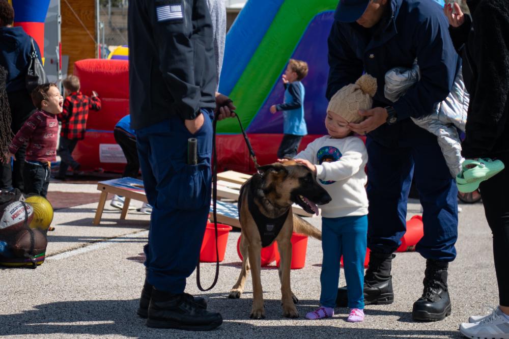 A child pets a Coast Guard K9 during Sector Houston-Galveston’s Community Day in Houston, Texas, Feb. 11, 2023. During the event, Coast Guard members from Sector Houston-Galveston and surrounding units displayed equipment and discussed various Coast Guard missions. (U.S. Coast Guard photo by Petty Officer 3rd Class Alejandro Rivera)