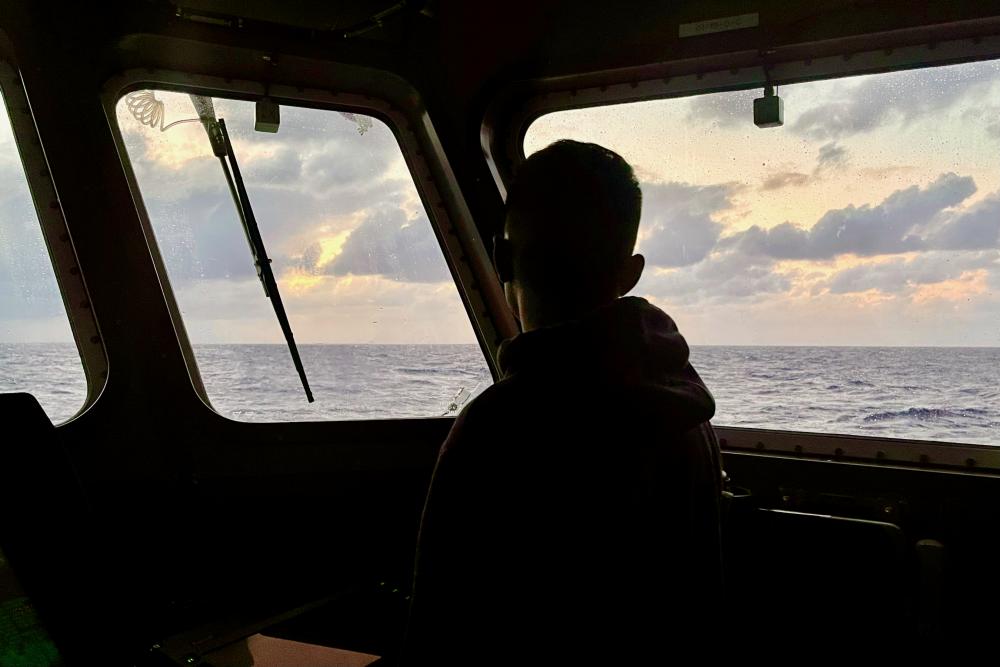 Lt. j.g. Dale Walters keeps a lookout from the bridge of the USCGC Myrtle Hazard (WPC 1139) for a missing 31-year-old spearfisher near Blue Hole, Guam, on March 17, 2023.